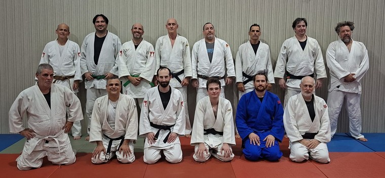 קבוצת ג׳ודופאן סיניורים מצטלמת יחד, שורה עומדת ושורה כורעת על המזרן