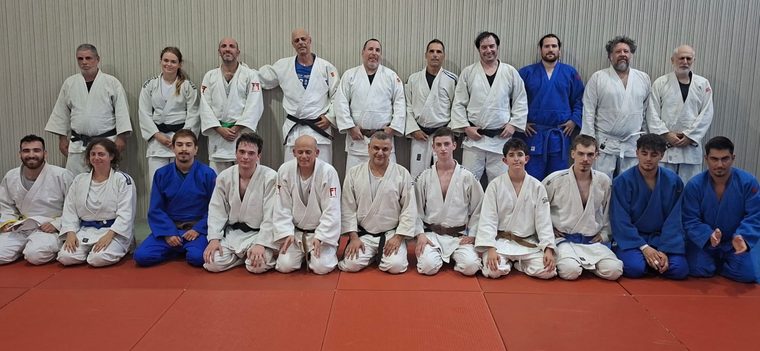 קבוצת ג׳ודופאן סיניורים מצטלמת יחד, שורה עומדת ושורה כורעת על המזרן